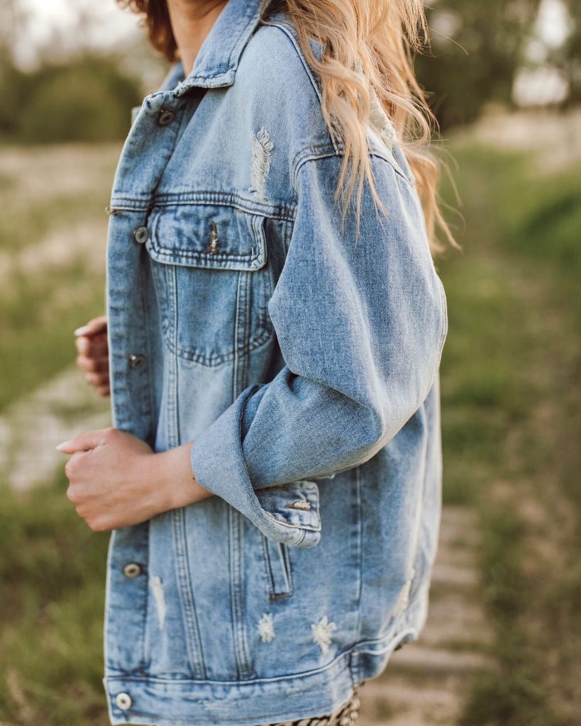 Giacca corta di jeans con dettagli sfrangiati e inserto ricamato sulle spalle