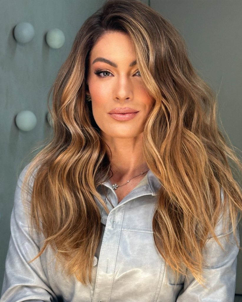 Balayage caramello su capelli castani con onde voluminose