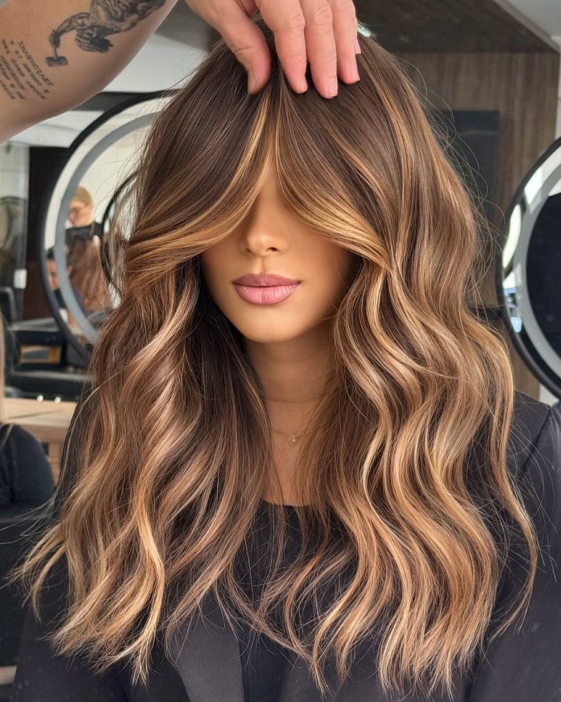 Balayage caramello su capelli castani con styling casual