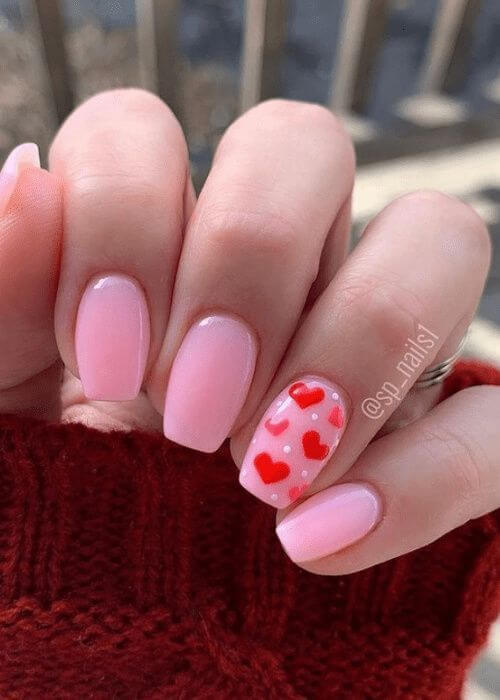 Manicure San Valentino con dettagli intrecciati rossi su base rosa